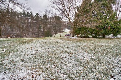 Large level backyard backed by wooded land owned b