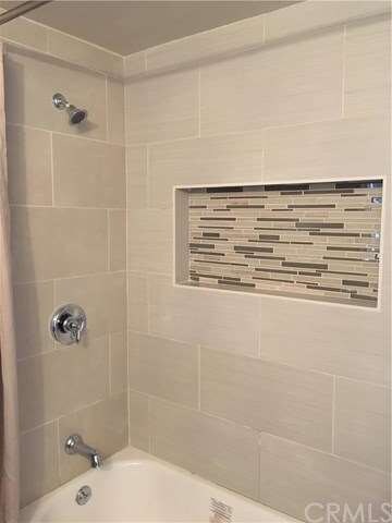 Brand new bathtub/ shower featuring a recessed shower shelf.