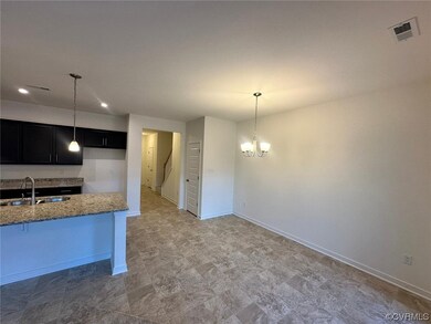 Kitchen featuring tile floors, sink, light stone countertops, and hanging light fixtures