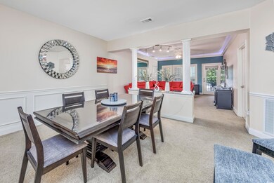 Carpeted dining room featuring ornamental molding 