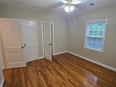 Unfurnished bedroom featuring wood finished floors and baseboards
