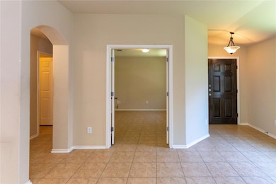 Empty room featuring arched walkways, light tile 
