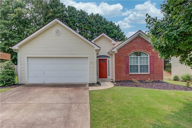 Ranch-style home with driveway, a front lawn, brick siding, and a garage