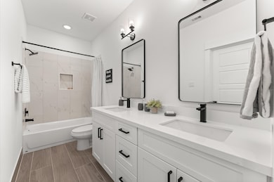 Beautifully appointed Jack and Jill bathroom nestled between the two secondary bedrooms on the first floor, designed to balance style and functionality. Each bedroom enjoys private access to the shared space, which features a sleek tub-shower combo—perfect for both quick rinses and relaxing soaks.