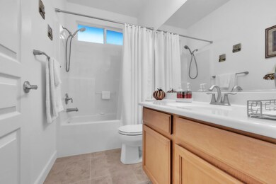 The guest bathroom is filled with natural light and fresh air, featuring trendy tile floors and a handheld shower head.