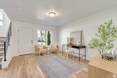 Sitting room with stairway and light wood finished floors