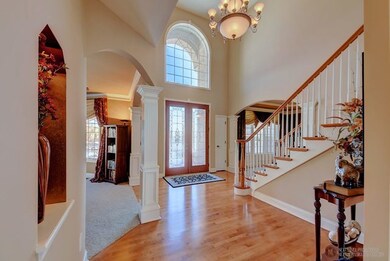 Two-story foyer with decorative alcoves, double do