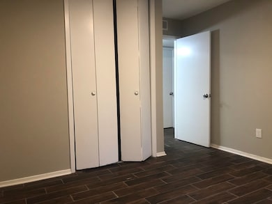 Unfurnished bedroom featuring dark wood-style floo