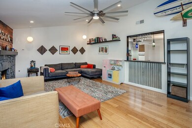 The family room is bathed in natural light and is enhanced by modern recessed lighting, lighted ceiling fan, stone fireplace, sliding glass doors that lead to the backyard and rich hardwood floors.