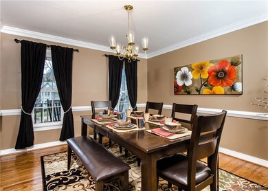 The dining room has hardwood flooring, crown and c