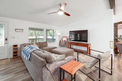 Living room featuring vaulted ceiling, light wood
