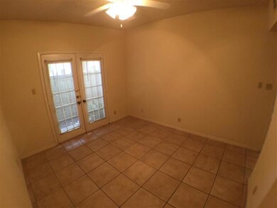 Empty room with french doors, light tile patterne