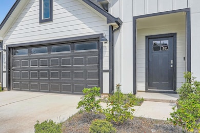 Property entrance featuring a garage and board an