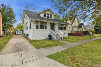 Bungalow-style house with roof with shingles, driveway, a front lawn, and a shed