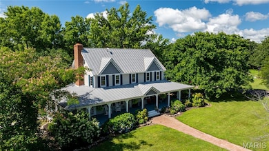 View of front of house featuring a porch, a metal roof, a chimney, and a front lawn