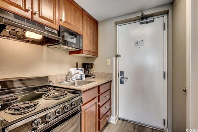 Kitchen with sink, black appliances, a textured ce