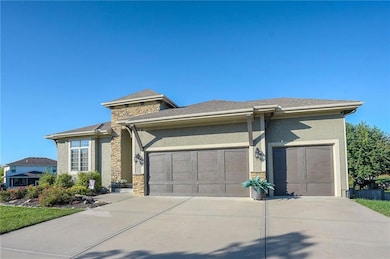 Prairie-style home with stone siding, a garage, driveway, stucco siding, and roof with shingles