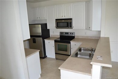 Stainless steel appliances and sleek white cabinet