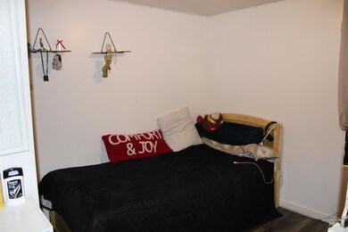 Bedroom featuring dark wood-type flooring and baseboards