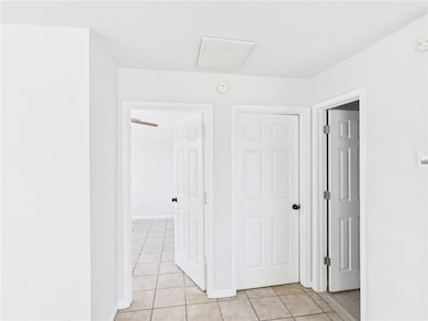 Corridor with light tile patterned flooring and ba