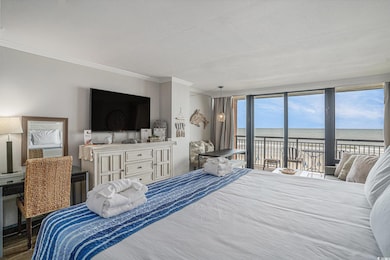 Bedroom with access to exterior, crown molding, and wood finished floors