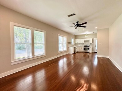 Unfurnished living room with ceiling fan, dark wo