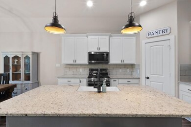 Kitchen featuring backsplash, range with gas cookt