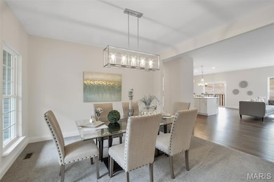 Dining area with dark carpet and a chandelier