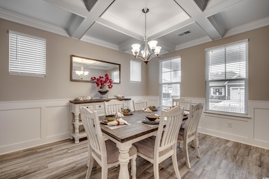 Dining room featuring coffered ceiling, light wood