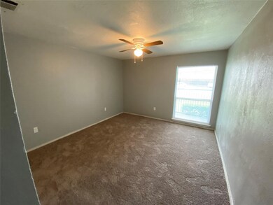 Carpeted spare room with a textured ceiling and a ceiling fan