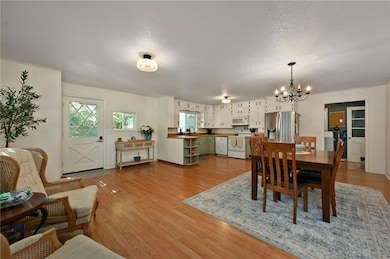 Dining area featuring a chandelier, light wood-style floors, and a textured ceiling