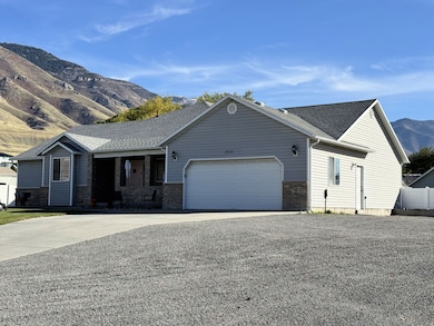 Ranch-style house with a mountain view, concrete driveway, a porch, and roof with shingles