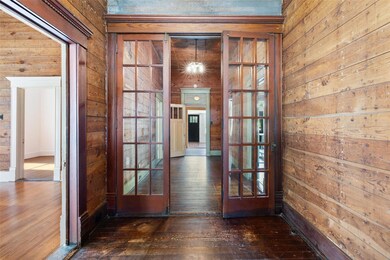 Entryway with wood-type flooring and wooden walls