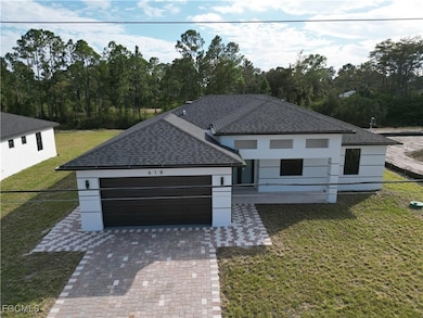 View of front of home featuring decorative driveway, roof with shingles, and a garage