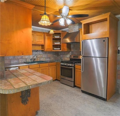 Kitchen featuring open shelves, stainless steel a