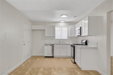 Kitchen featuring stainless steel appliances, a si