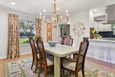 Dining room with light wood-style flooring, a chandelier, and recessed lighting
