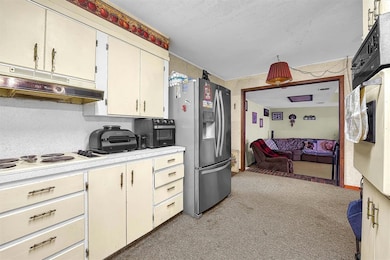 Kitchen with white electric stovetop, light counte