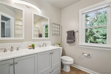 Bathroom featuring toilet, vanity, plenty of natur