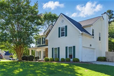 Traditional-style home with a chimney, an attached garage, concrete driveway, and stucco siding