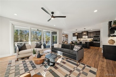 Living area featuring wood finished floors, baseboards, a ceiling fan, and recessed lighting