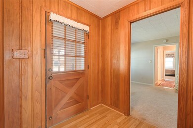 Entryway with light colored carpet and wooden wall