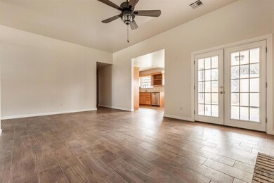 Unfurnished living room featuring french doors, ceiling fan, and dark wood-style flooring