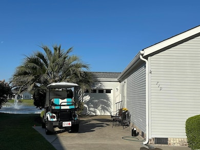 View of car parking featuring driveway and a water
