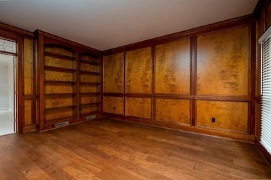 Spare room with built in shelves and wood finished floors