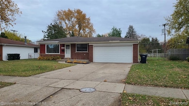 Single story home with brick siding, a garage, driveway, and roof with shingles