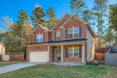 View of front of house with brick siding, a porch, a garage, and concrete driveway