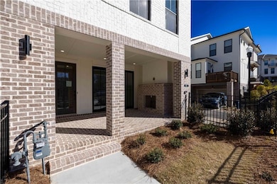 Enter through the gated front yard to a covered brick patio.