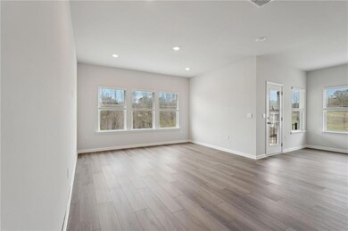 Unfurnished living room featuring baseboards and w