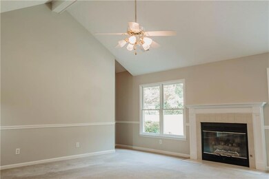 Unfurnished living room with a ceiling fan, light carpet, and a fireplace